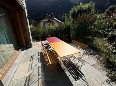 a wooden table and chairs sitting on a patio at Superbe chalet vallée de Chamonix in Chamonix-Mont-Blanc