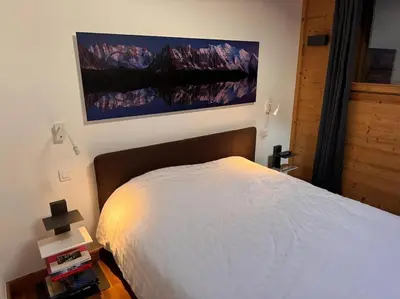 a bedroom with a bed and a painting on the wall at Superbe chalet vallée de Chamonix in Chamonix-Mont-Blanc