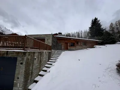 a house with a deck in the snow at Superbe chalet vallée de Chamonix in Chamonix-Mont-Blanc