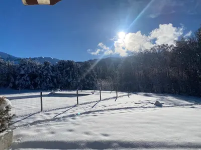 a fence in a snow covered field with the sun at Grand Studio à 300m du pied des pistes, in Megève