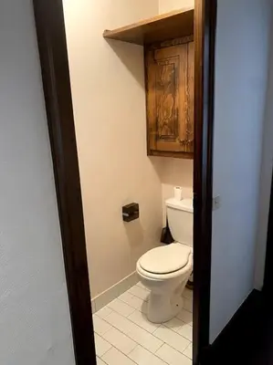 a bathroom with a toilet and a wooden cabinet at Grand Studio à 300m du pied des pistes, in Megève