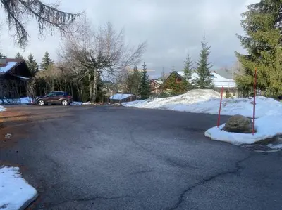 a parking lot with snow on the side of the road at Grand Studio à 300m du pied des pistes, in Megève