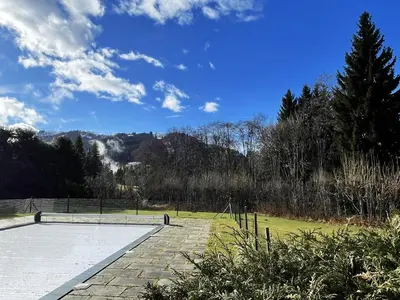 a tennis court in a park with a blue sky at Grand Studio à 300m du pied des pistes, in Megève