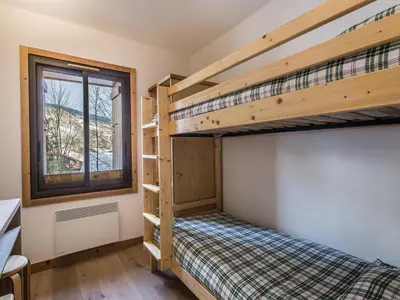a bedroom with two bunk beds and a window at Appartement 3 chambres avec terrasse au cœur de Megève - FR-1-453-316 in Megève