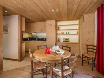 a kitchen and dining room with a wooden table and chairs at Appartement 3 chambres avec terrasse au cœur de Megève - FR-1-453-316 in Megève