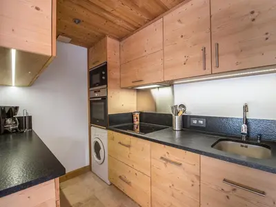 a kitchen with wooden cabinets and a sink and a dishwasher at Appartement 3 chambres avec terrasse au cœur de Megève - FR-1-453-316 in Megève