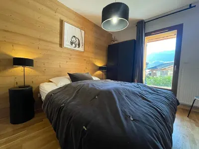 a bedroom with a bed and a large window at Appartement lumineux avec parking à Samoëns, animaux admis - FR-1-624-170 in Samoëns