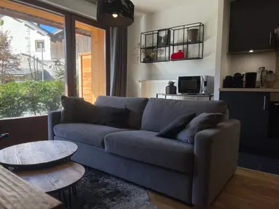 a living room with a blue couch and a table at Appartement lumineux avec parking à Samoëns, animaux admis - FR-1-624-170 in Samoëns