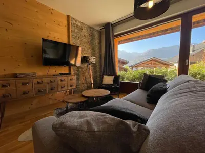 a living room with a couch and a tv at Appartement lumineux avec parking à Samoëns, animaux admis - FR-1-624-170 in Samoëns
