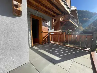 a porch of a house with a wooden door at Appartement lumineux avec parking à Samoëns, animaux admis - FR-1-624-170 in Samoëns