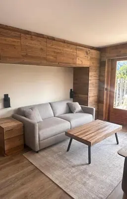 a living room with a couch and a coffee table at Studio Cosy cœur de Megève Le Soleil Levant in Megève