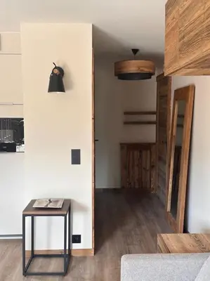 a living room with a table and a hallway at Studio Cosy cœur de Megève Le Soleil Levant in Megève
