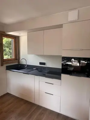 a kitchen with white cabinets and a sink at Studio Cosy cœur de Megève Le Soleil Levant in Megève