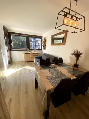 a living room with a table and a couch at Appt Cosy au centre Chamonix in Chamonix-Mont-Blanc