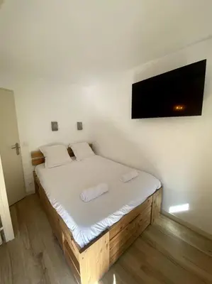 a bedroom with a bed with a tv on the wall at Appt Cosy au centre Chamonix in Chamonix-Mont-Blanc