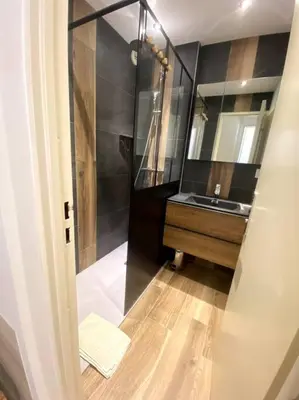 a bathroom with a sink and a shower with a mirror at Appt Cosy au centre Chamonix in Chamonix-Mont-Blanc