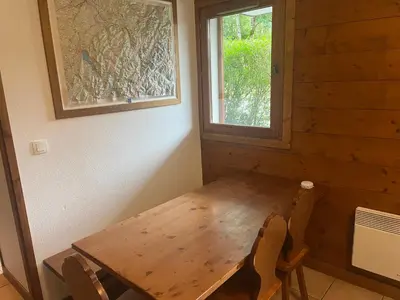 a wooden table and chairs in a room with a window at Appartement Samoëns in Samoëns