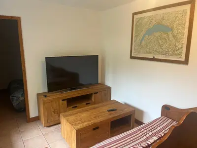 a living room with a television and a wooden entertainment center at Appartement Samoëns in Samoëns