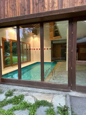 a swimming pool in a house with windows at Appartement Samoëns in Samoëns