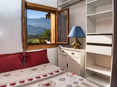 a small bedroom with a bed and a window at La Charlotte in Sallanches