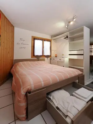 a bedroom with a large bed and a mirror at La Charlotte in Sallanches