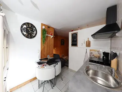 a kitchen with a sink and a clock on the wall at La Charlotte in Sallanches