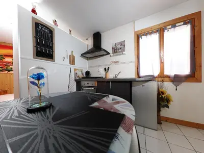 a kitchen with a table with an umbrella on it at La Charlotte in Sallanches