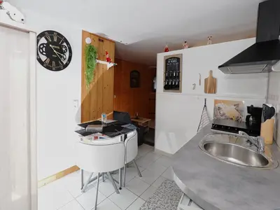 a kitchen with a sink and a clock on the wall at La Charlotte in Sallanches