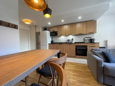 a kitchen and living room with a wooden table and chairs at Appartement lumineux avec terrasse et parking à Samoëns - FR-1-624-171 in Samoëns