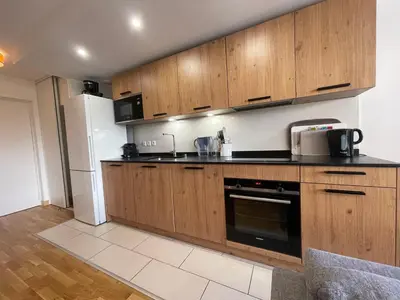 a kitchen with wooden cabinets and a refrigerator at Appartement lumineux avec terrasse et parking à Samoëns - FR-1-624-171 in Samoëns