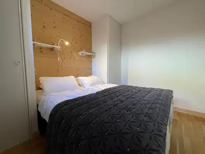 a bedroom with a bed and a wooden wall at Appartement lumineux avec terrasse et parking à Samoëns - FR-1-624-171 in Samoëns