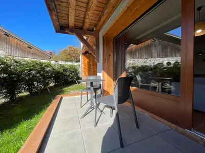 a patio with two chairs and a table on it at Appartement lumineux avec terrasse et parking à Samoëns - FR-1-624-171 in Samoëns