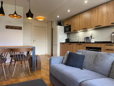 a living room with a couch and a table and a kitchen at Appartement lumineux avec terrasse et parking à Samoëns - FR-1-624-171 in Samoëns