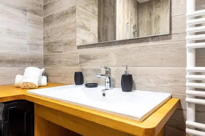 a bathroom with a white sink and a mirror at Appartement des Cristaux - Welkeys in Megève