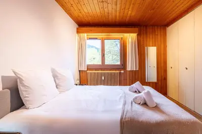 a bedroom with a large white bed with a window at Appartement des Cristaux - Welkeys in Megève