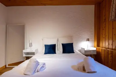 a bedroom with a large white bed with blue pillows at Appartement des Cristaux - Welkeys in Megève