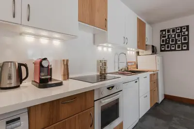 a kitchen with white appliances and wooden cabinets at Bel Oiseau - Hypercentre - Balcon -Chamonix in Chamonix-Mont-Blanc