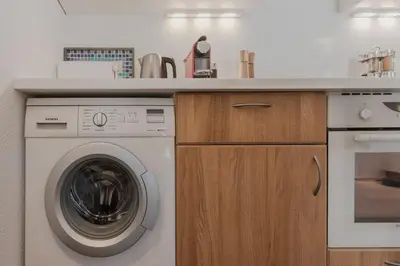 a kitchen with a washing machine under a counter at Bel Oiseau - Hypercentre - Balcon -Chamonix in Chamonix-Mont-Blanc