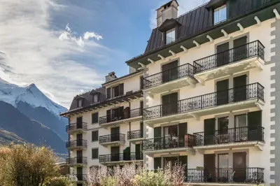 a building with balconies and mountains in the background at Bel Oiseau - Hypercentre - Balcon -Chamonix in Chamonix-Mont-Blanc