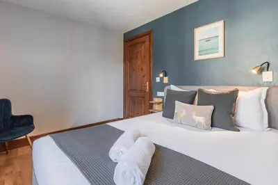 a bedroom with a large bed and a chair at Bel Oiseau - Hypercentre - Balcon -Chamonix in Chamonix-Mont-Blanc