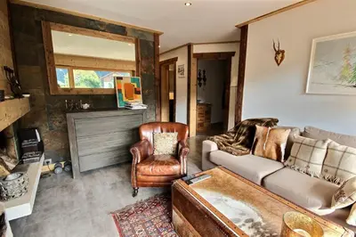 a living room with a couch and a chair at Cosy apartment with fireplace close to the slopes in Megève