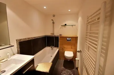 a bathroom with a tub and a toilet and a sink at Cosy apartment with fireplace close to the slopes in Megève