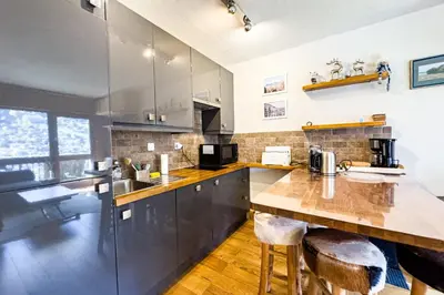 a kitchen with stainless steel appliances and wooden floors at Apartment with mountain view in Saint-Gervais in Saint-Gervais-les-Bains