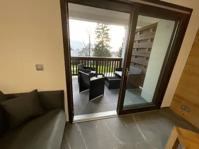a living room with a couch and a large sliding glass door at Le Manoir d Ernesta in Passy