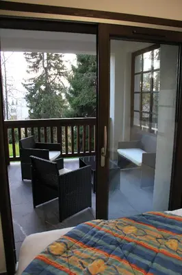 a bedroom with a balcony with a bed and chairs at Le Manoir d Ernesta in Passy