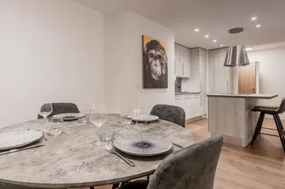 a dining room with a table and chairs and a kitchen at Le 002 - Proche Telecabine - Terrasse in Saint-Gervais-les-Bains