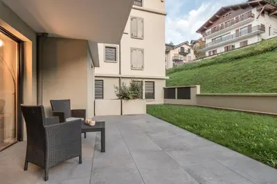 a patio with a table and chairs and a green yard at Le 002 - Proche Telecabine - Terrasse in Saint-Gervais-les-Bains