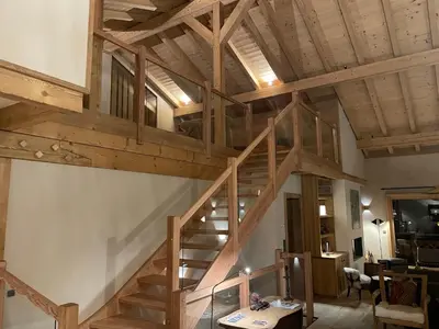 a wooden staircase in a living room with wooden ceilings at Chalet prestige Saint Gervais les Bains in Saint-Gervais-les-Bains