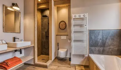 a bathroom with a tub and a sink and a toilet at Chalet prestige Saint Gervais les Bains in Saint-Gervais-les-Bains