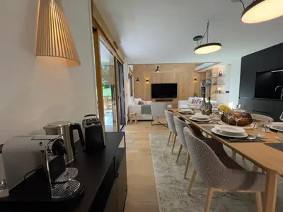 a kitchen and living room with a long dining table at Les cimes de l alpage - Duplex luxe 130 m2 au pied des pistes in Combloux